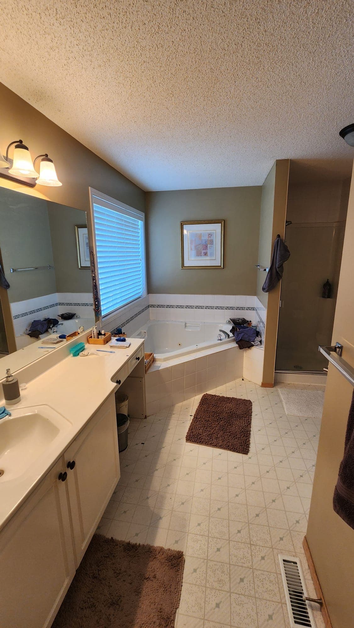Dated master ensuite with green walls and corner tub before renovation, Calgary