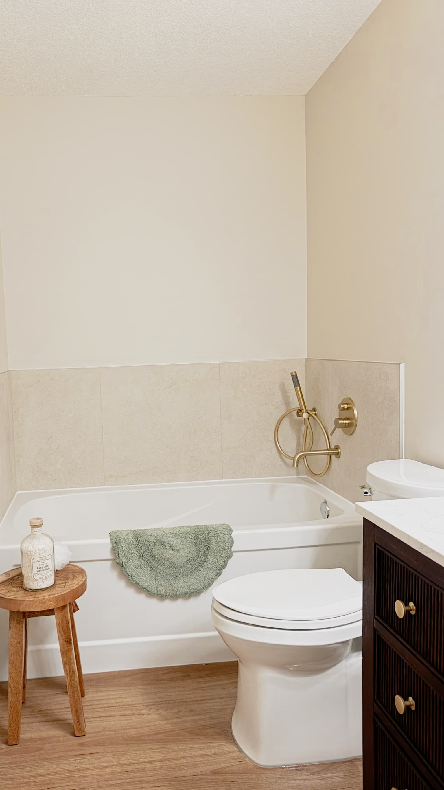 Refreshed bathroom with clean tile surround, brushed-gold fixtures and dark vanity, Calgary